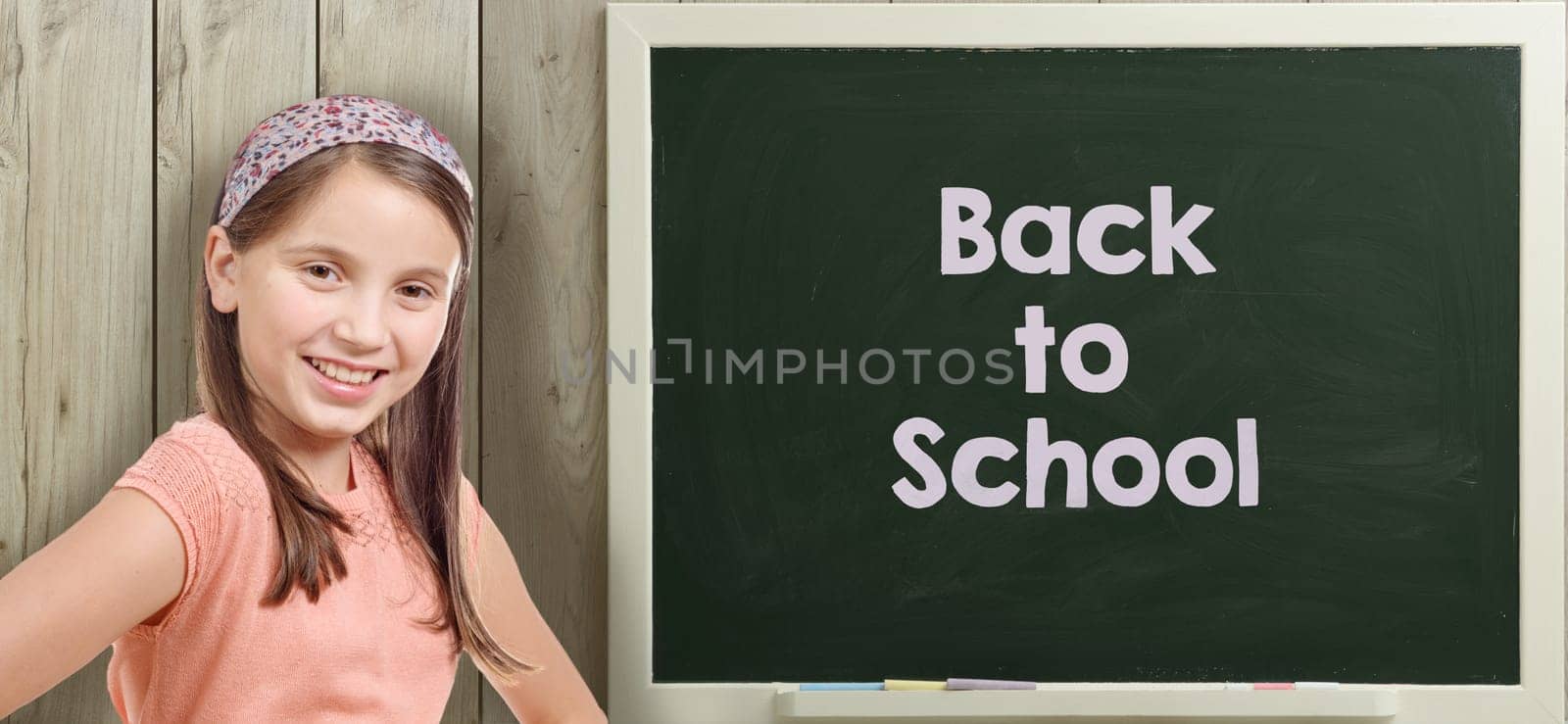 back to school written on  blackboard with pretty young girl