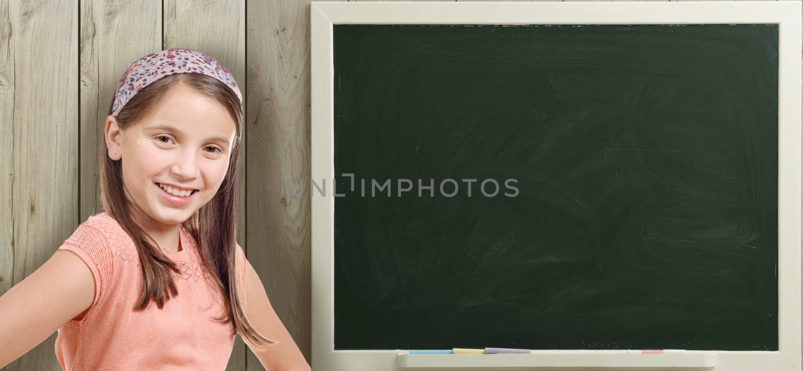 a pretty young girl and a green blackboard