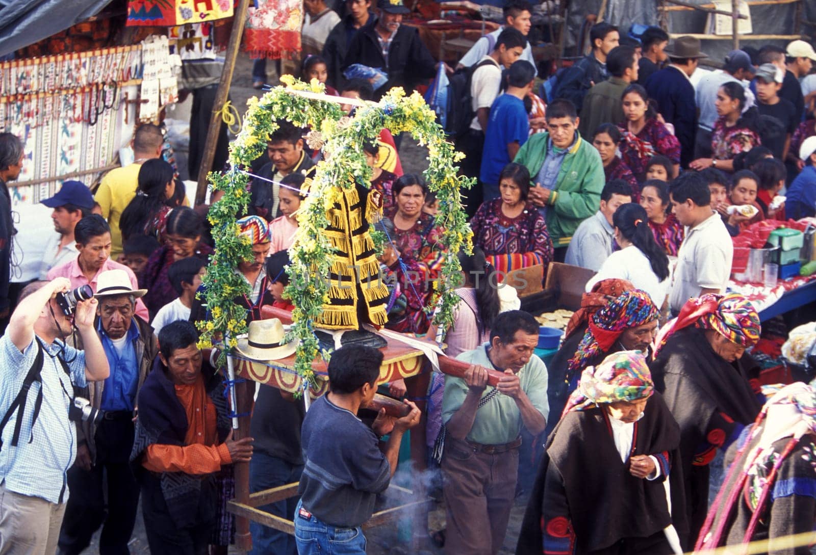 A relogion procession with people in traditional clotes at the Market in the Village of Chichi or Chichicastenango in Guatemala in central America.