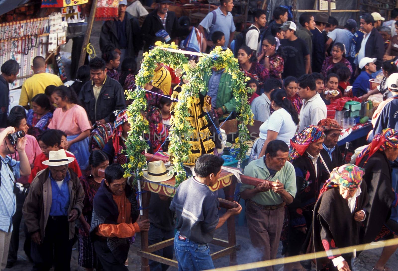 A relogion procession with people in traditional clotes at the Market in the Village of Chichi or Chichicastenango in Guatemala in central America.