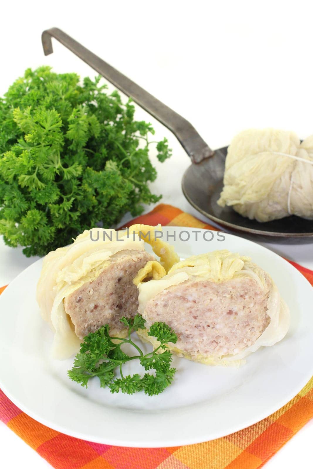 Wirsingroulade with parsley against a white background