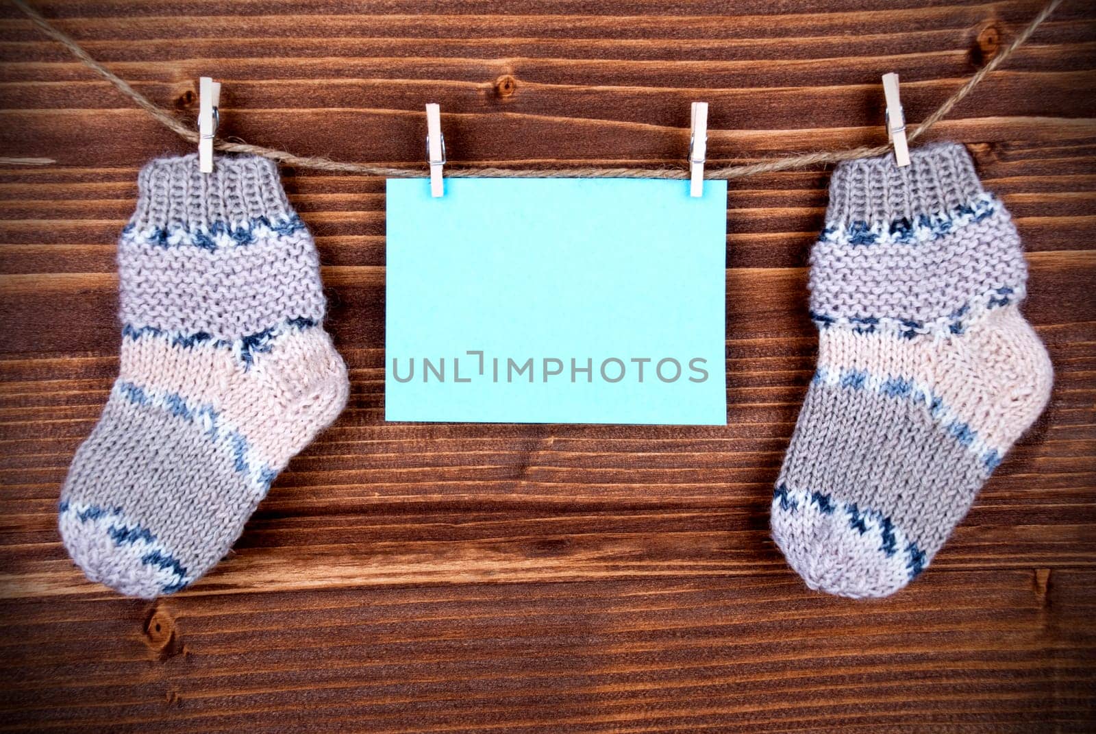 Blue Tag Or Label With Two Baby Socks On A Line With Copy Space For Your Free Text Here On Wooden Background, Vintage, Retro And Old Fashion Style With Frame