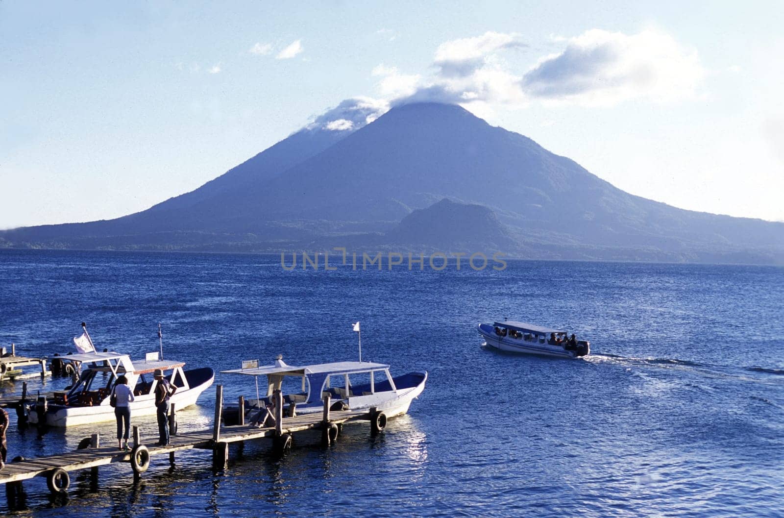 The Lake Atitlan with the Volcanos of Toliman and San Pedro in the back at the Town of Panajachel in Guatemala in Central America.