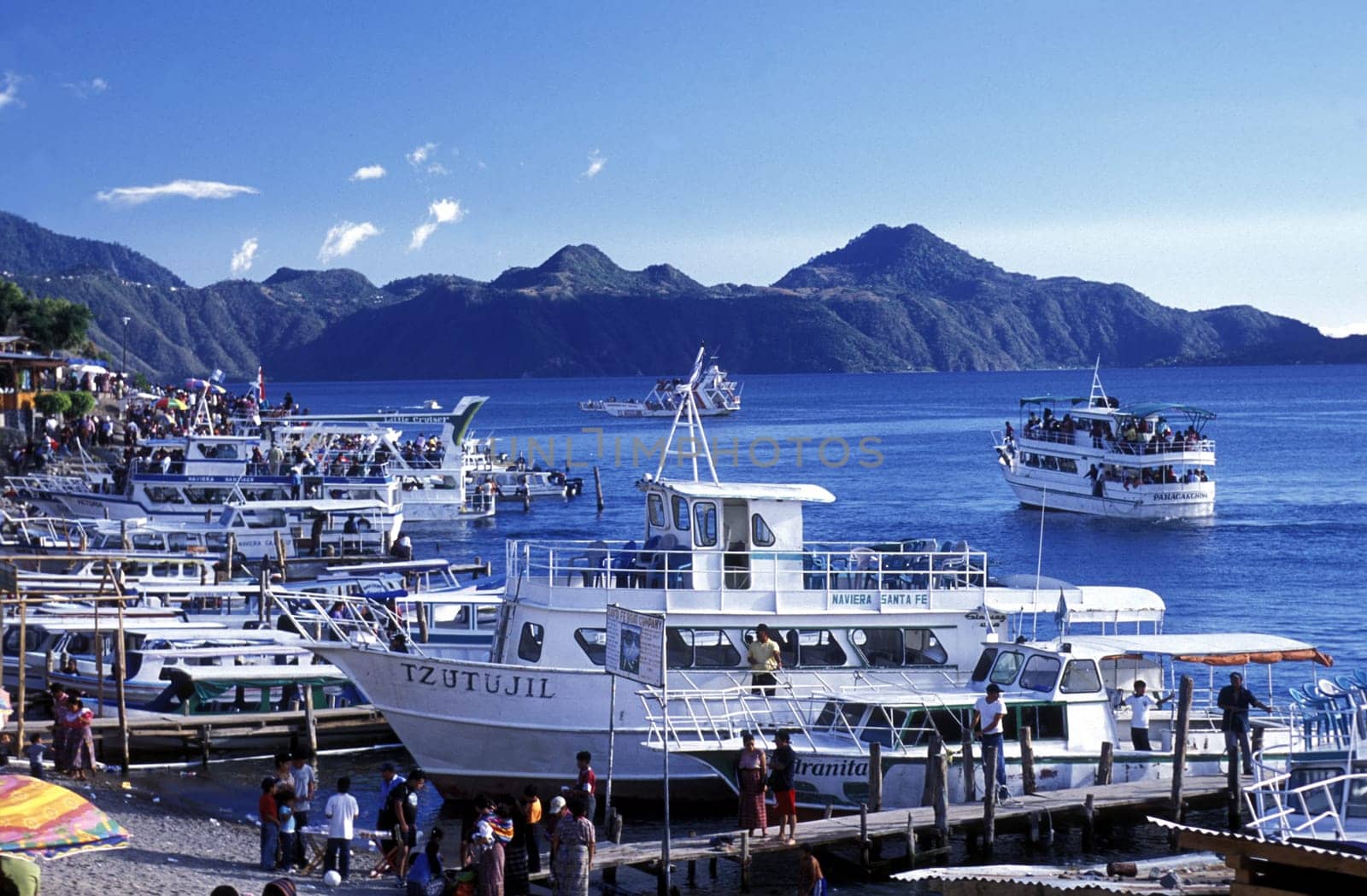 People at the coast of Lake Atitlan mit the Volcanos of Toliman and San Pedro in the back at the Town of Panajachel in Guatemala in central America.