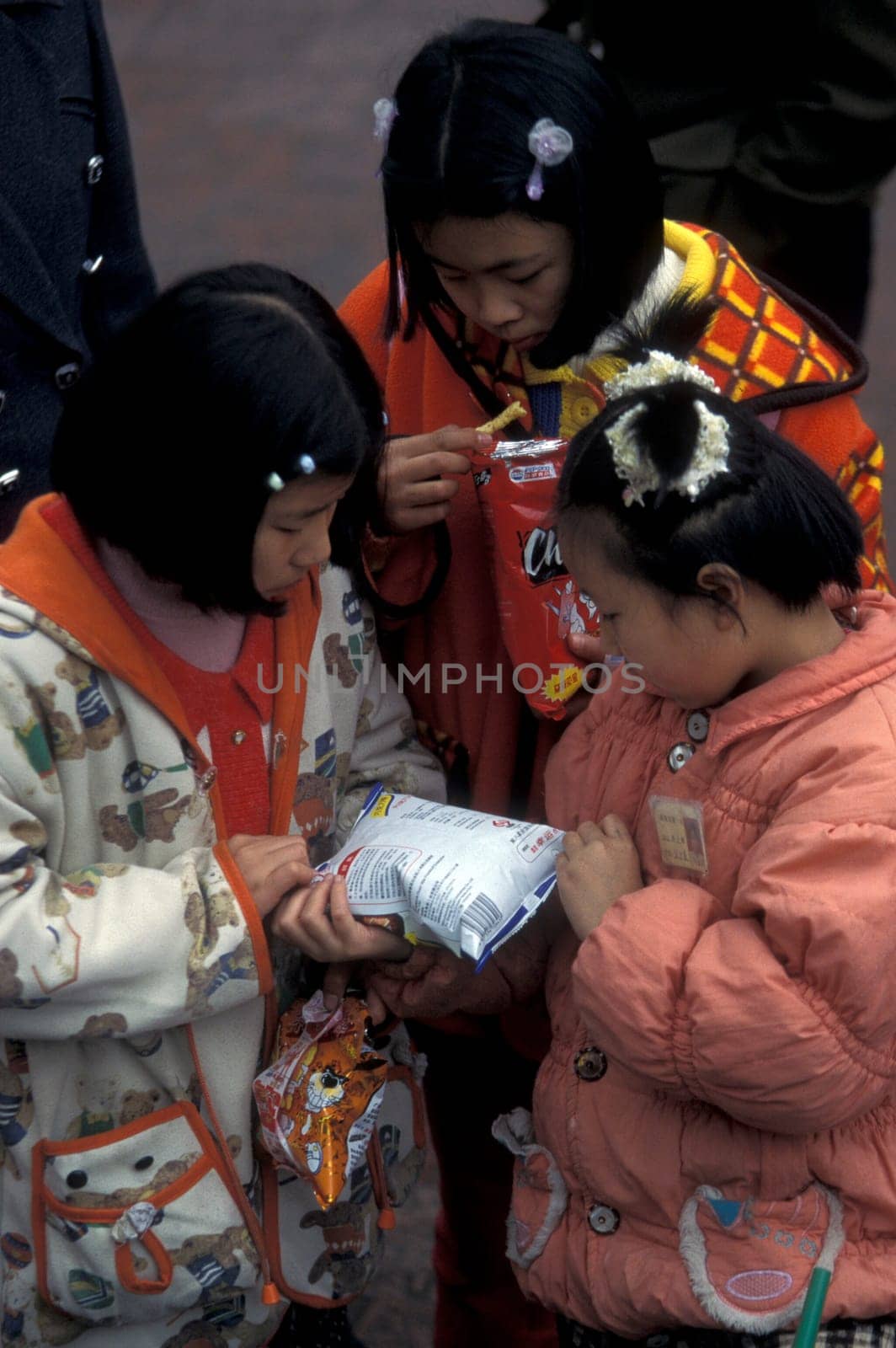 childern with some snaks on the streets of Chongqing in the province of Sichuan in china in east asia.