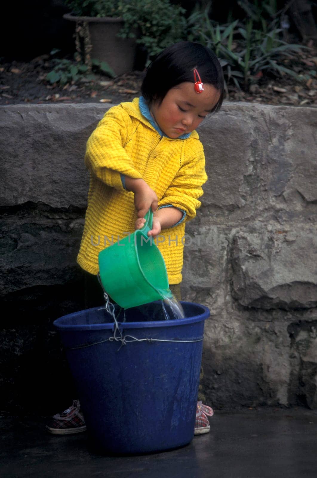 a girl get water at the main square in the city of Chongqing in the province of Sichuan in china in east asia.