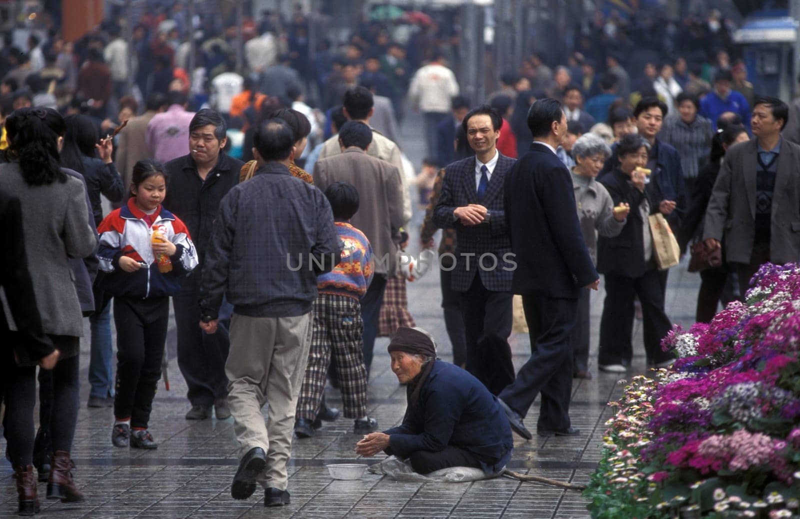 a poor wonen at a shopping street in the city of Chongqing in the province of Sichuan in china in east asia.