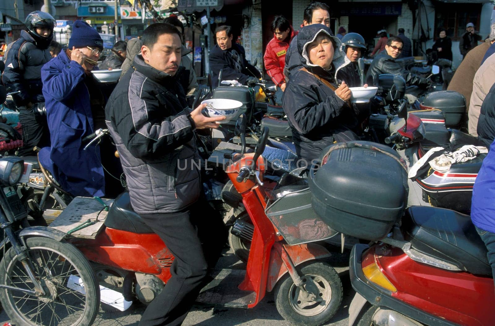 people eat a noodle soupe in the trafic line in the City of Shanghai in china in east asia.
