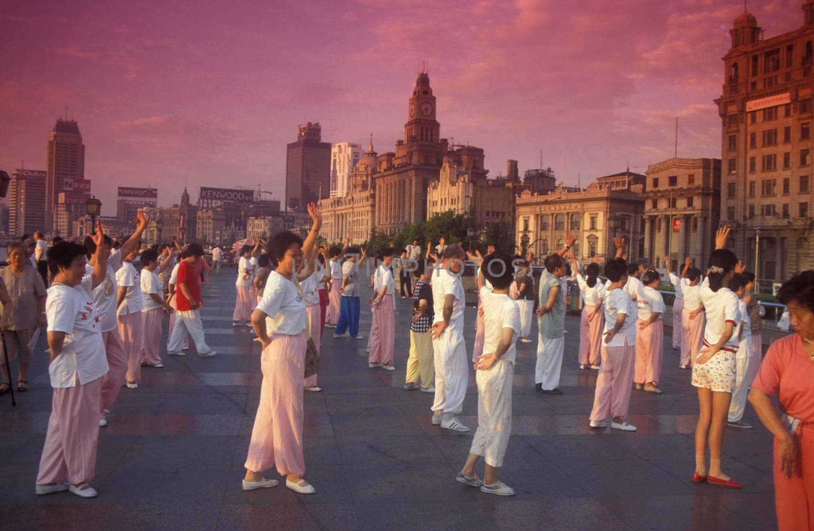 people dancing in the morning on the Bund in front of the skyline of Pudong in the City Shanghai in China.