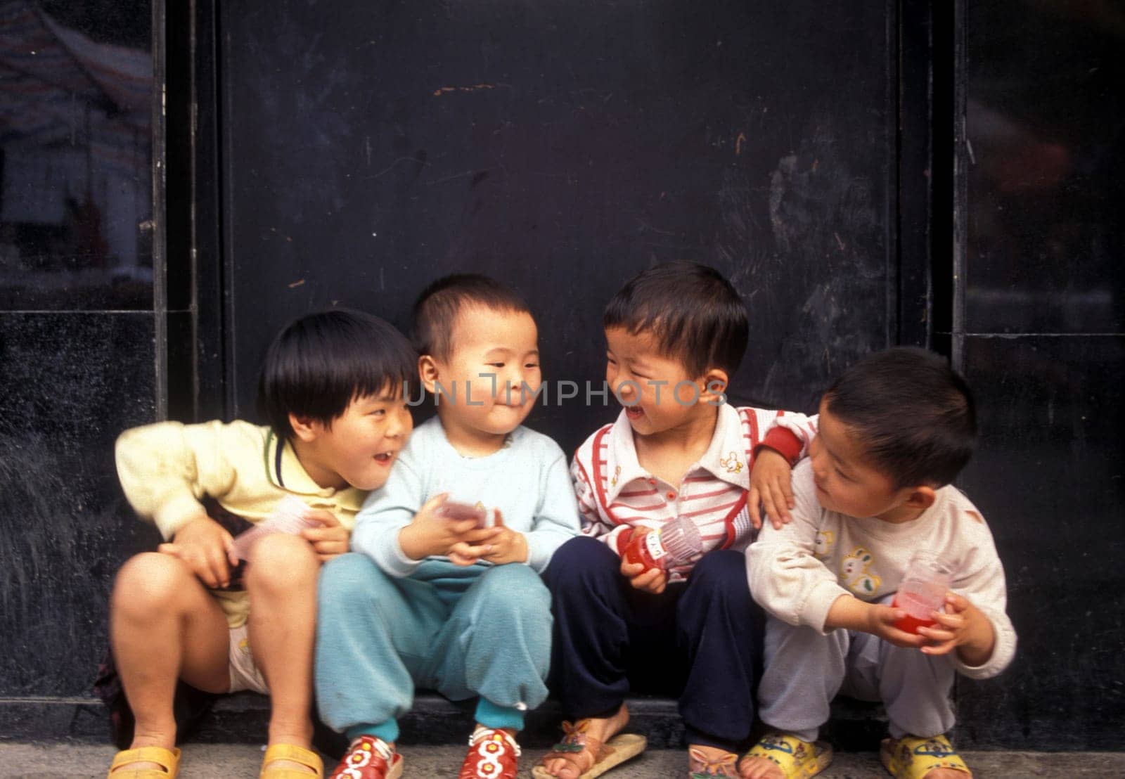 4 childern in a market street in the city of Shenzhen north of Hongkong in the province of Guangdong in china in east asia.