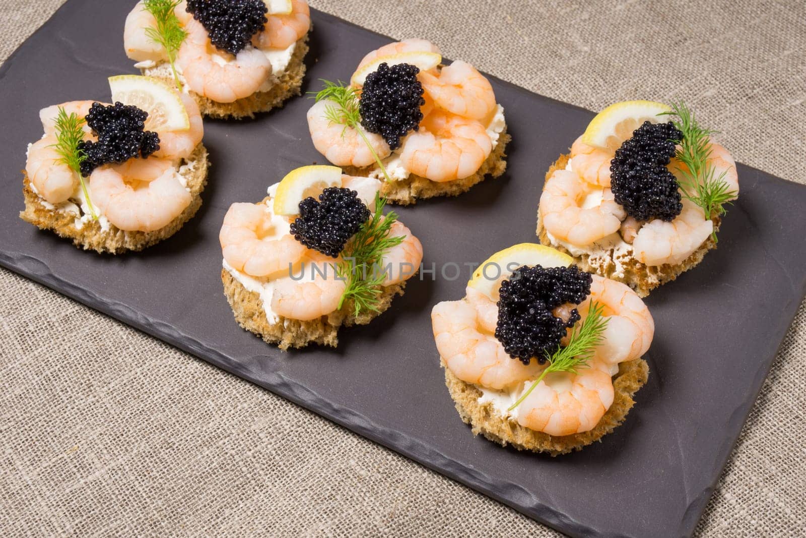 Shrimp Appetizer served on toasted bread and served on a slate plate