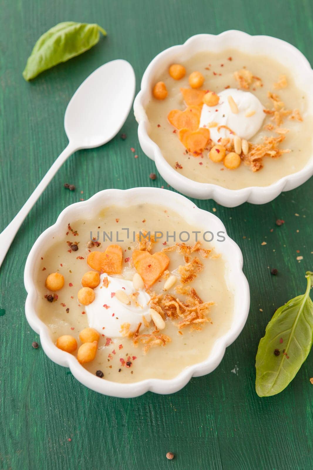 Homemade vegetable soup with crème fraiche and baked peas