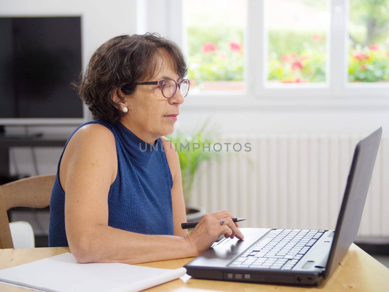 a beautiful mature woman with her laptop in the house
