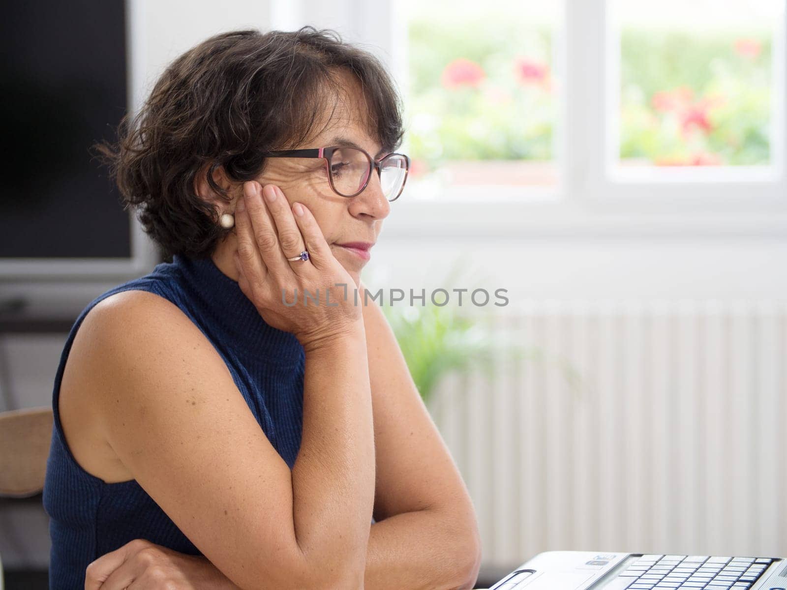 a beautiful mature woman with her laptop in the house