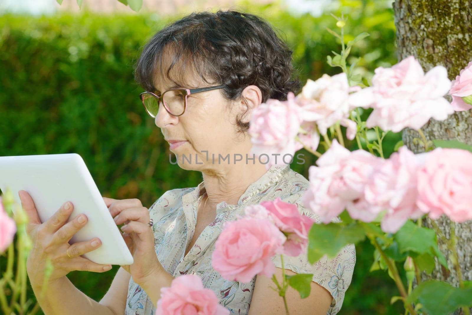 portrait of a mature woman with a tablet in his garden