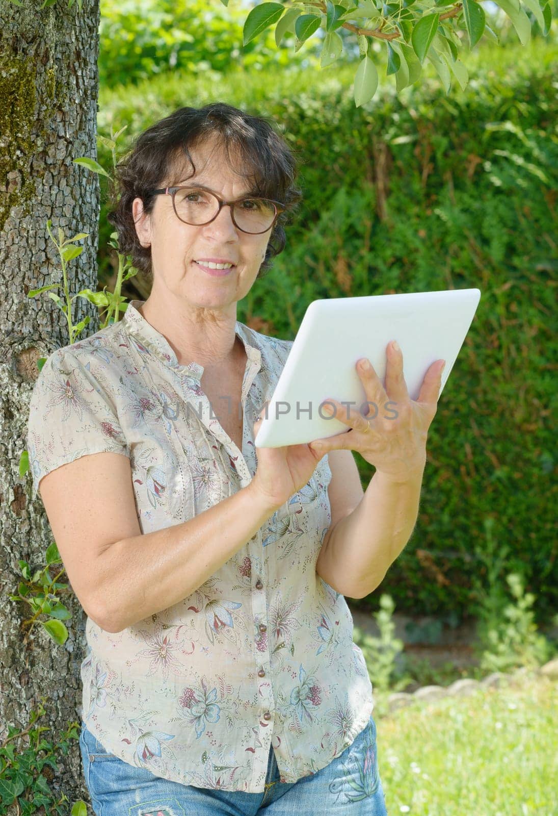 portrait of a mature woman with a tablet in his garden