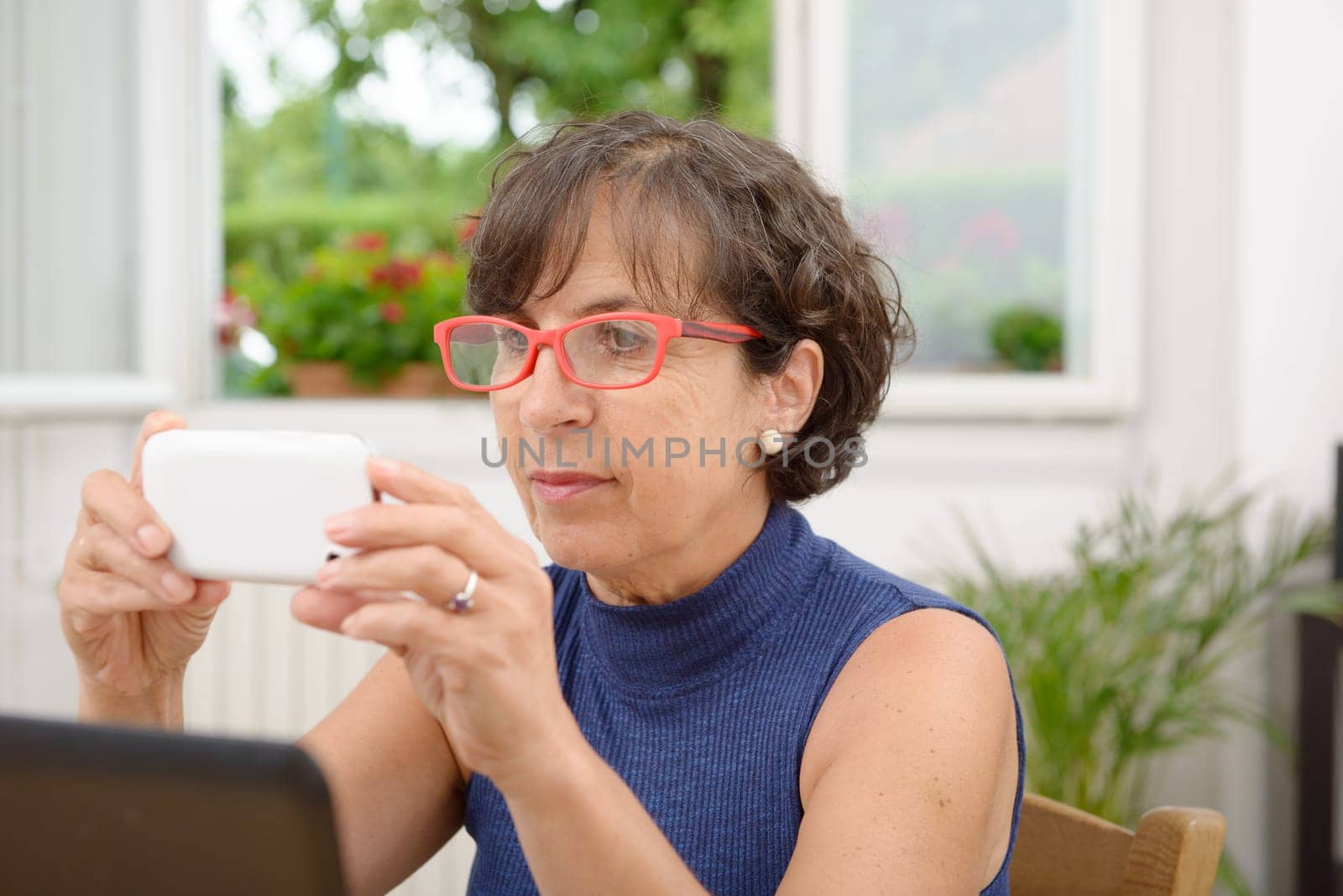 mature woman with red glasses and  phone