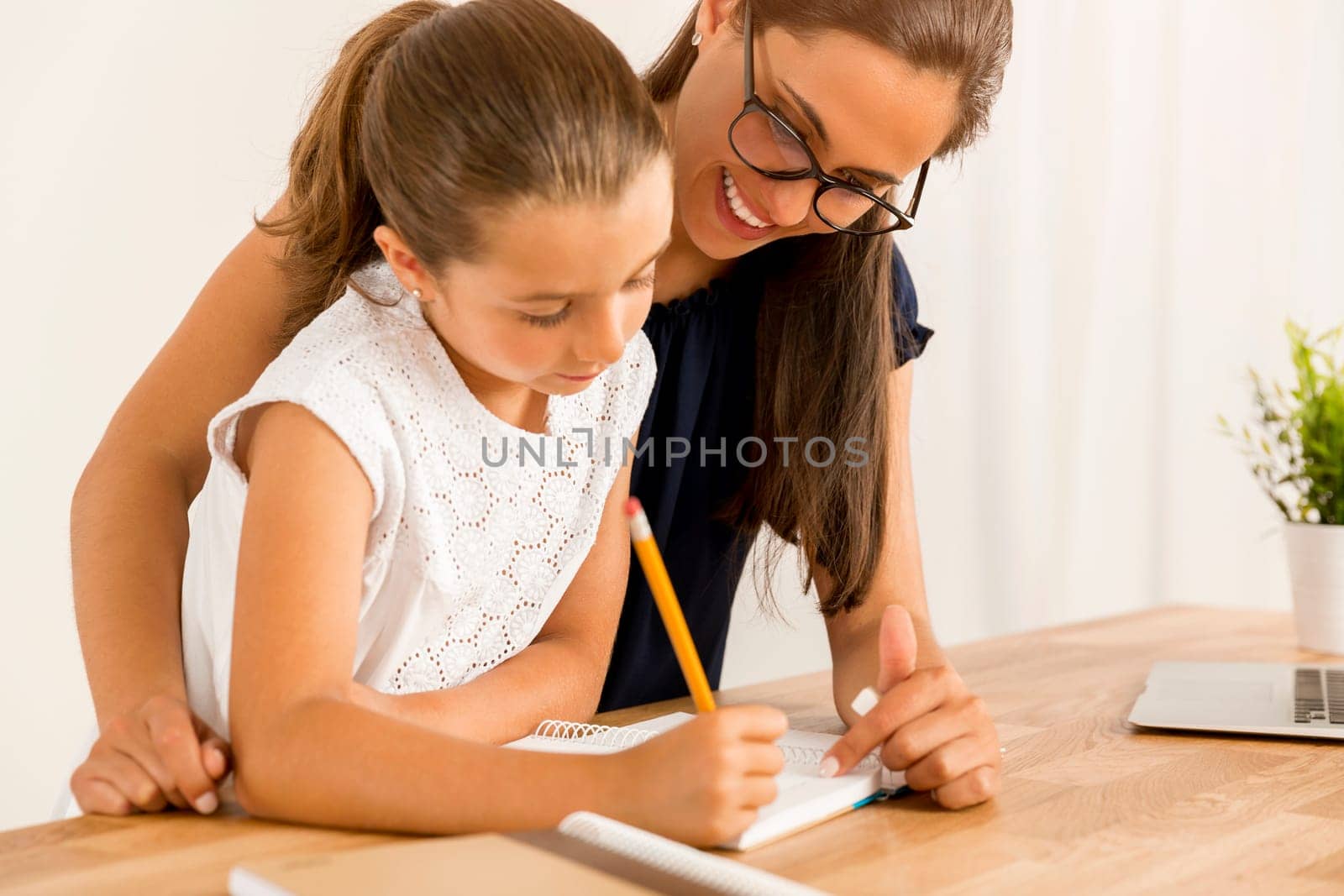 Mother and daugther at home doing homework together