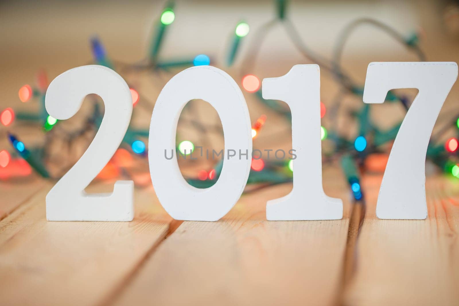 Numbers made of wood 2017 in front of colorful string of lights,selective focus