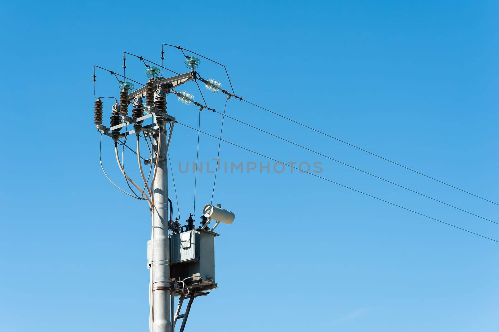 Electrical transformer to electrical pylon against the blue sky