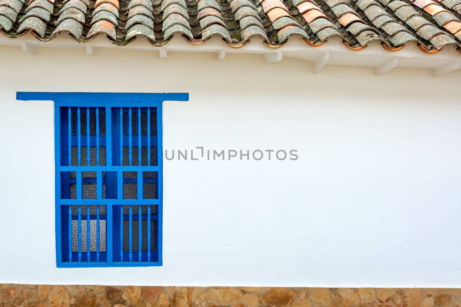 Facade of a historic colonial building with a blue window in Villa de Leyva, Colombia