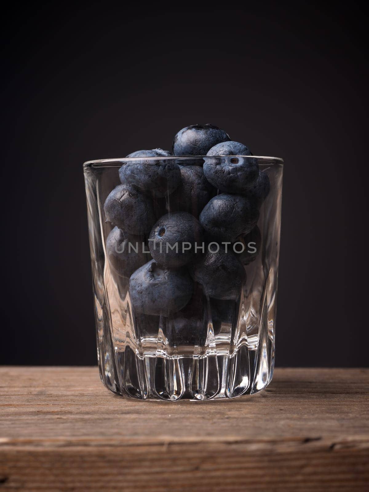 Blueberries in a glass on a wooden table, super food concept image