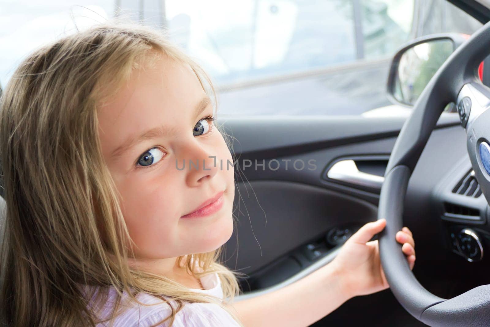 Cute girl driving car with blond long hair