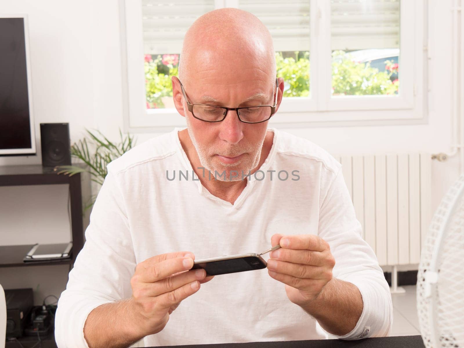 mature man repaired a smartphone