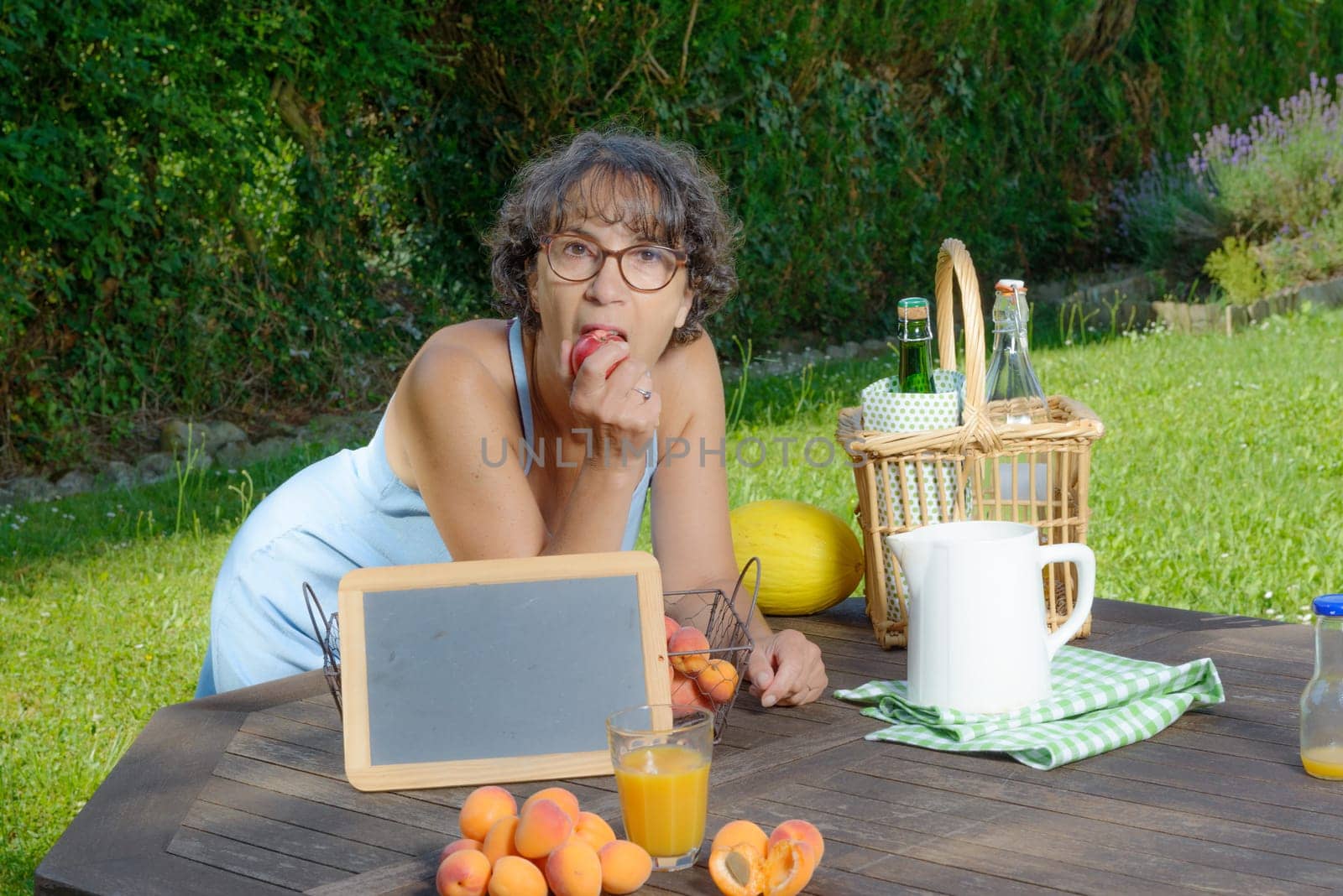 a woman eating a fruit in his garden