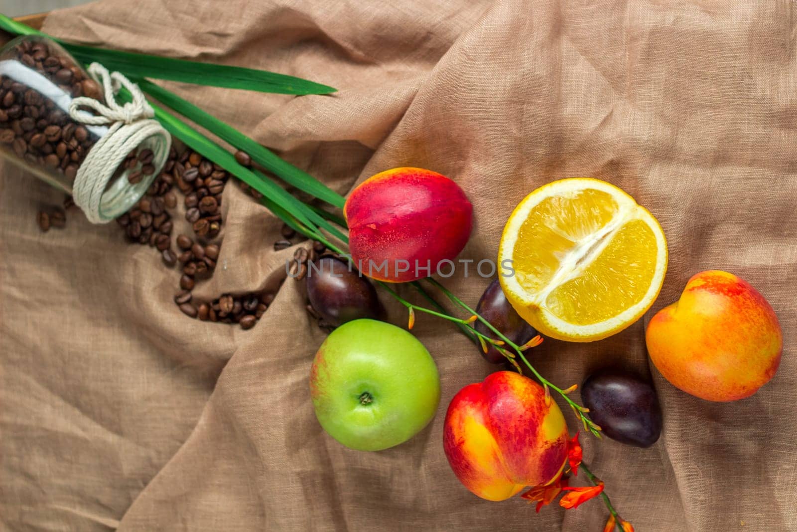 Still life on sackcloth background: apple, peaches, orance, plums