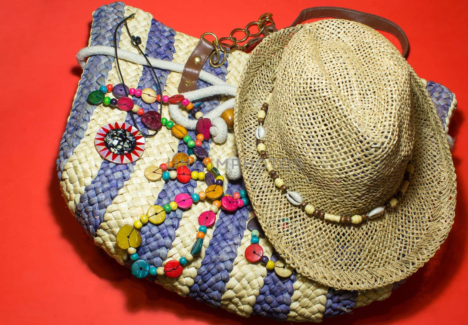 The stylish summer beach accessories. Vacation mood. Straw hat, bag and a beads.