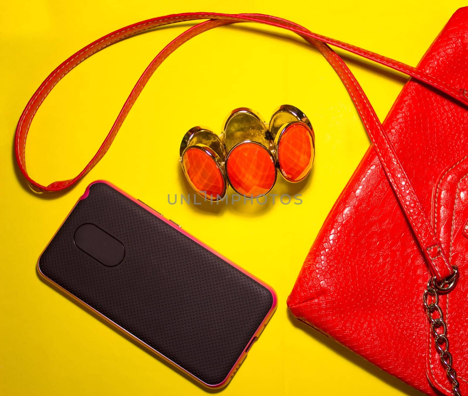 Top view of female accessories and smart phone on blue background