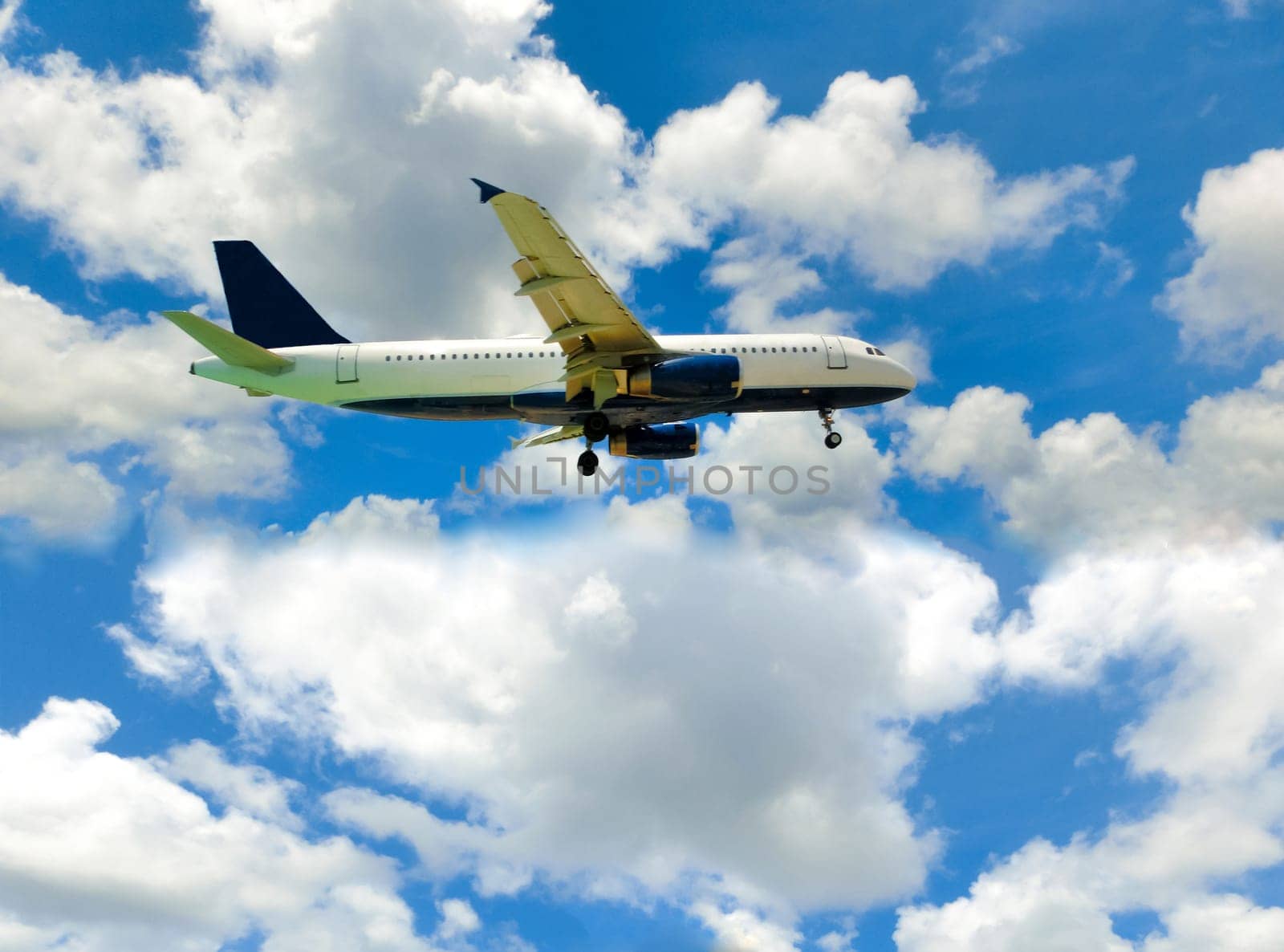 The airplane in the blue sky with clouds