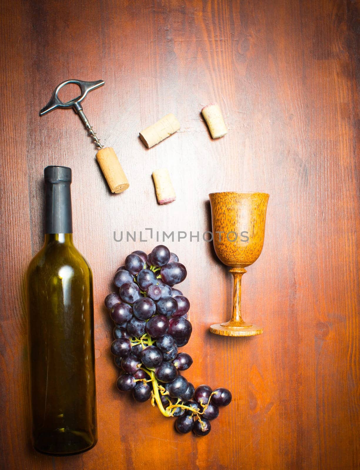 The empty bottle of wine with corkscrews and glass of coconut on wooden background