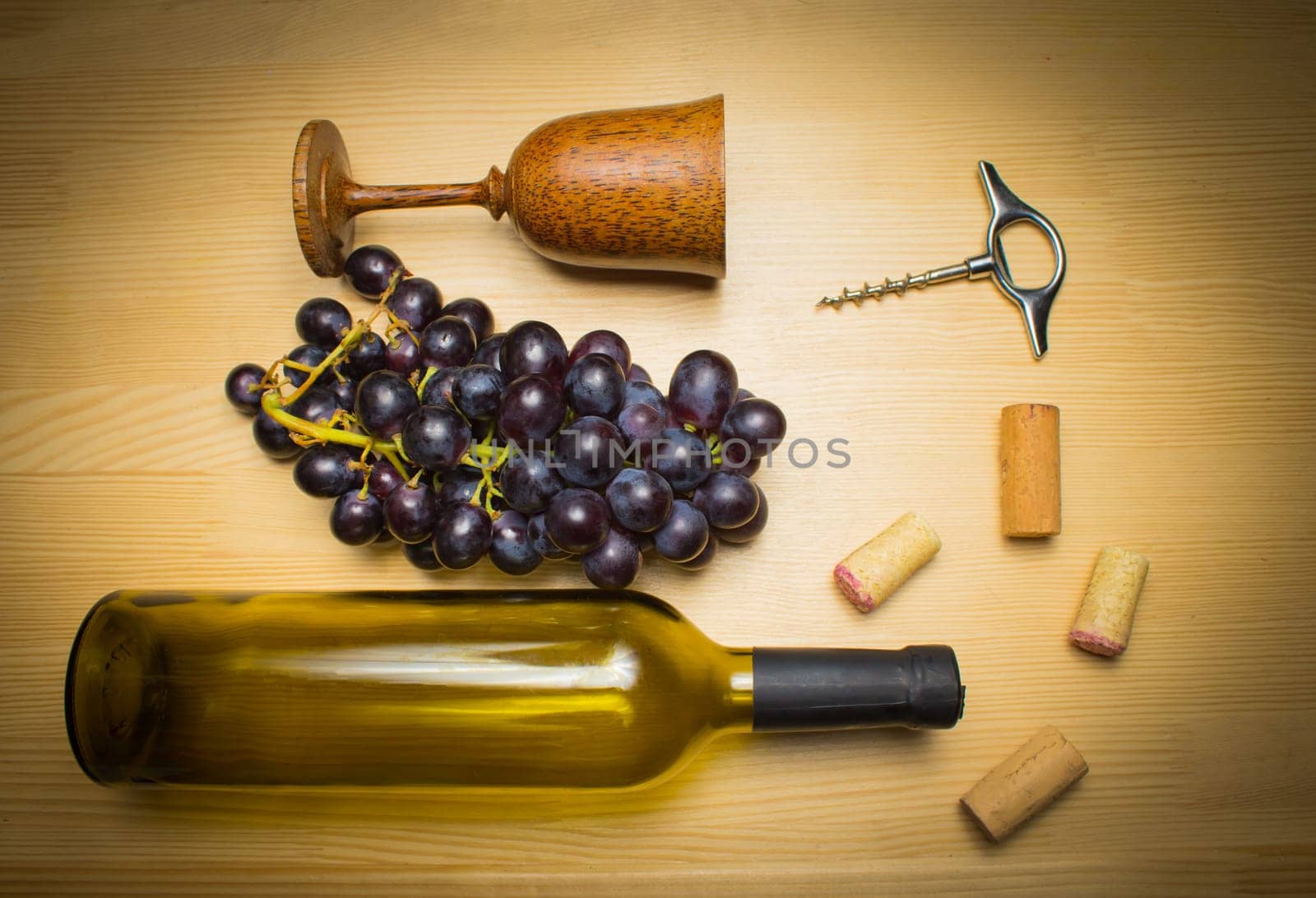 The empty bottle of wine with corkscrews and glass of coconut on wooden background