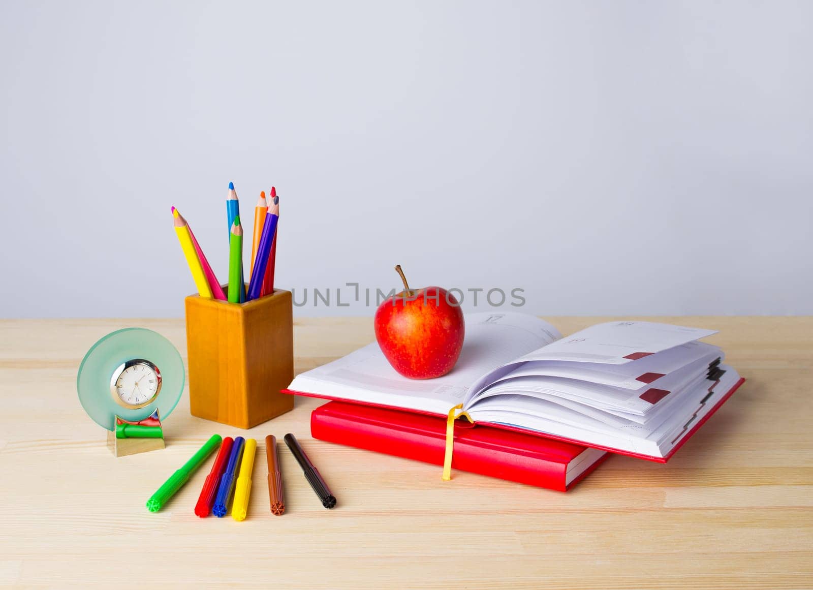 Back to school background with books, pencils and red apple over wooden table