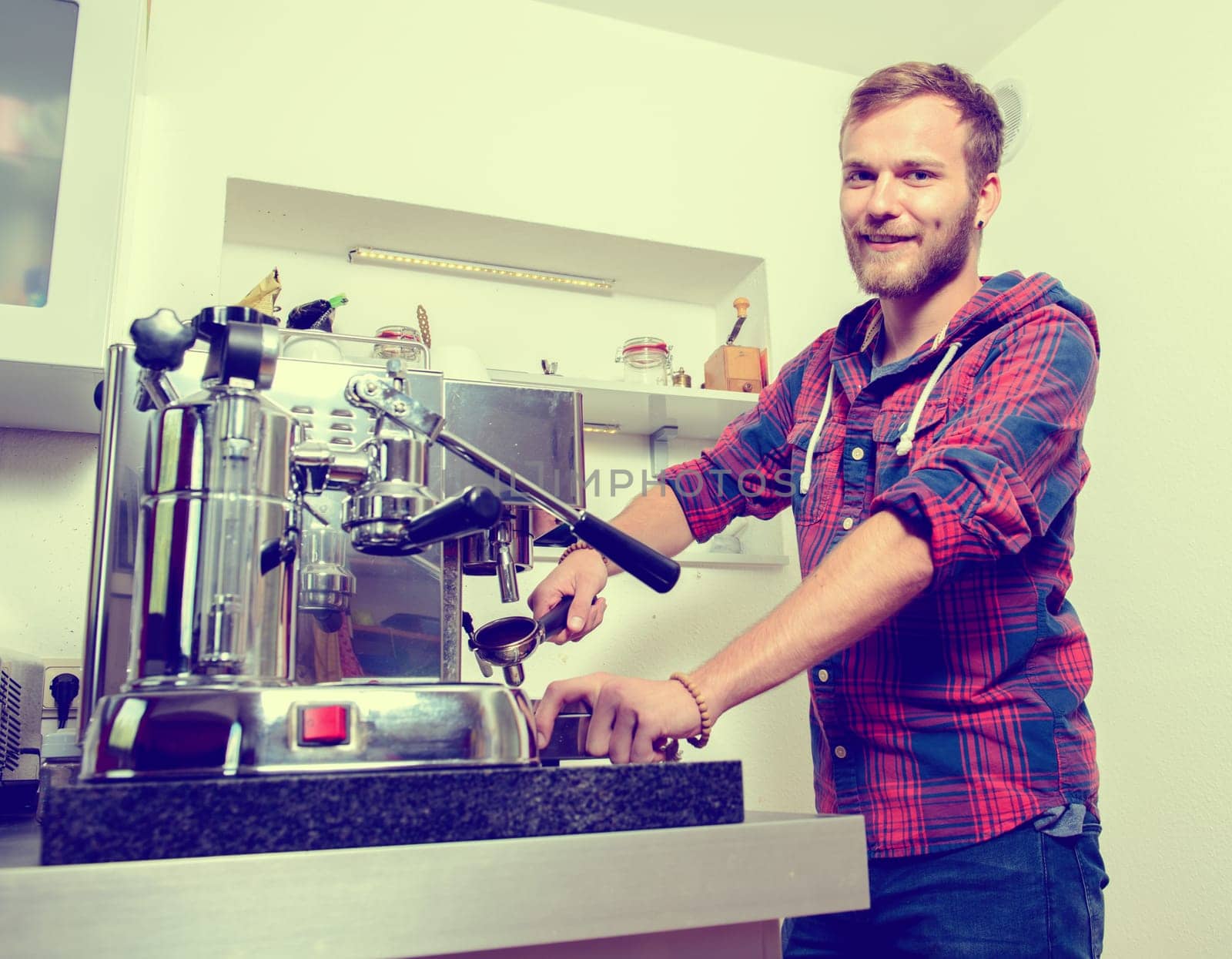 young bearded man in checkered shirt with his espresso machine