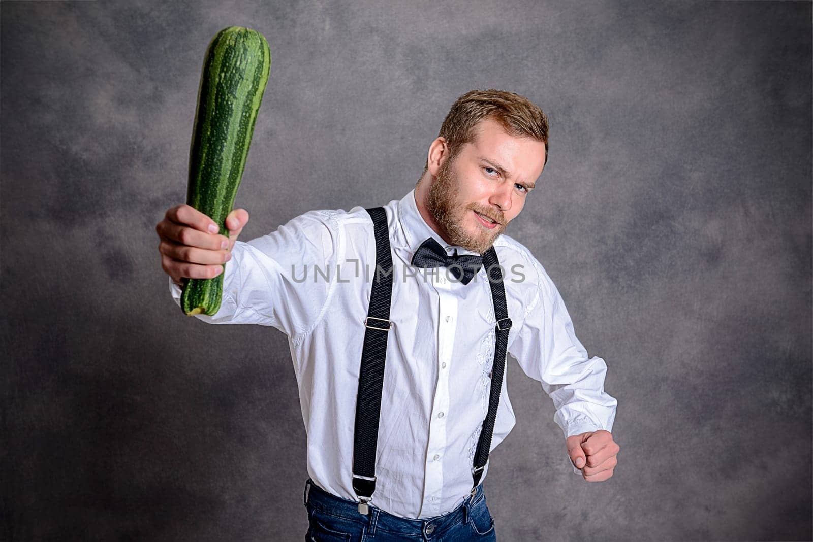 young angry vegetarian minatory with zucchini cudgel