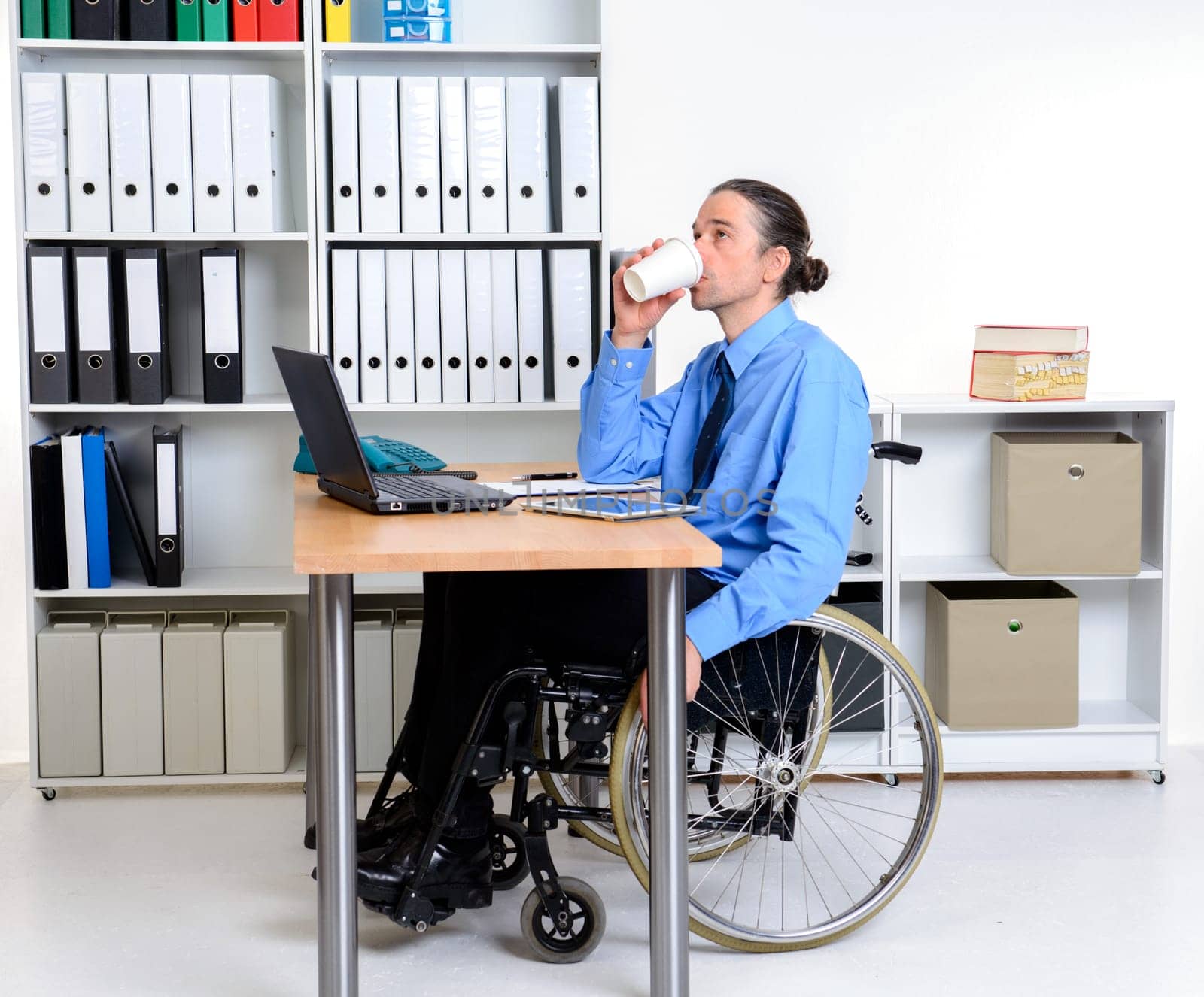 disabled business man in wheelchair drinking coffee in the office