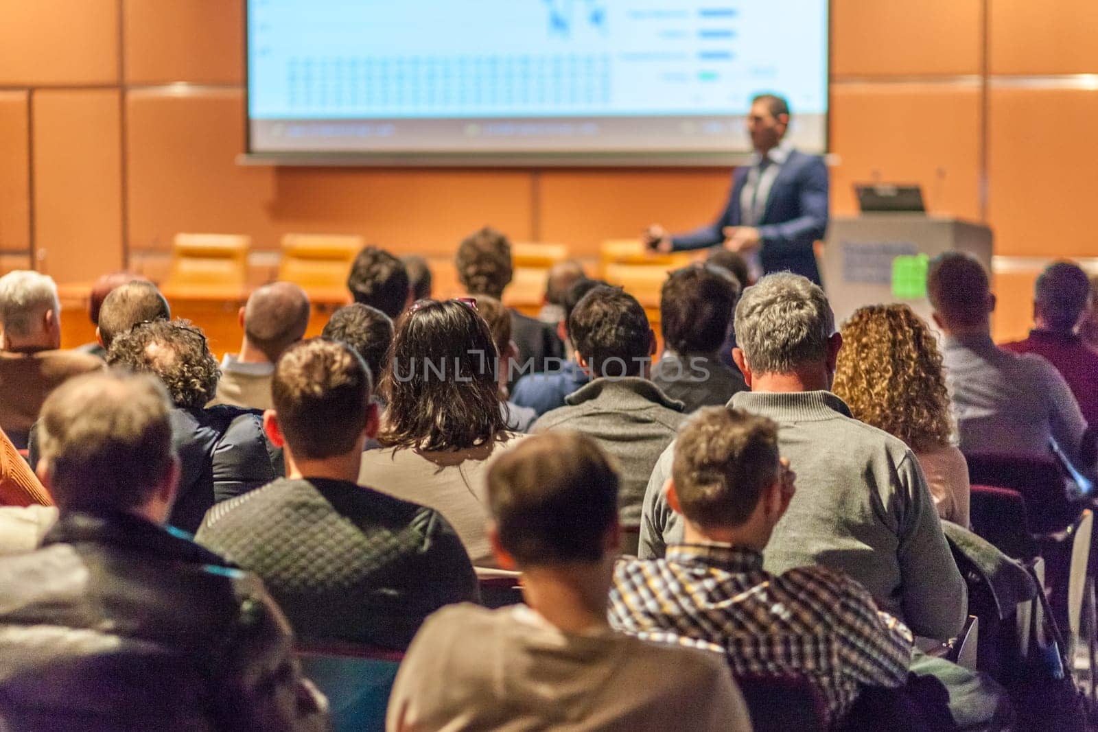 Speaker giving a talk in conference hall at business event. Audience at the conference hall. Business and Entrepreneurship concept.