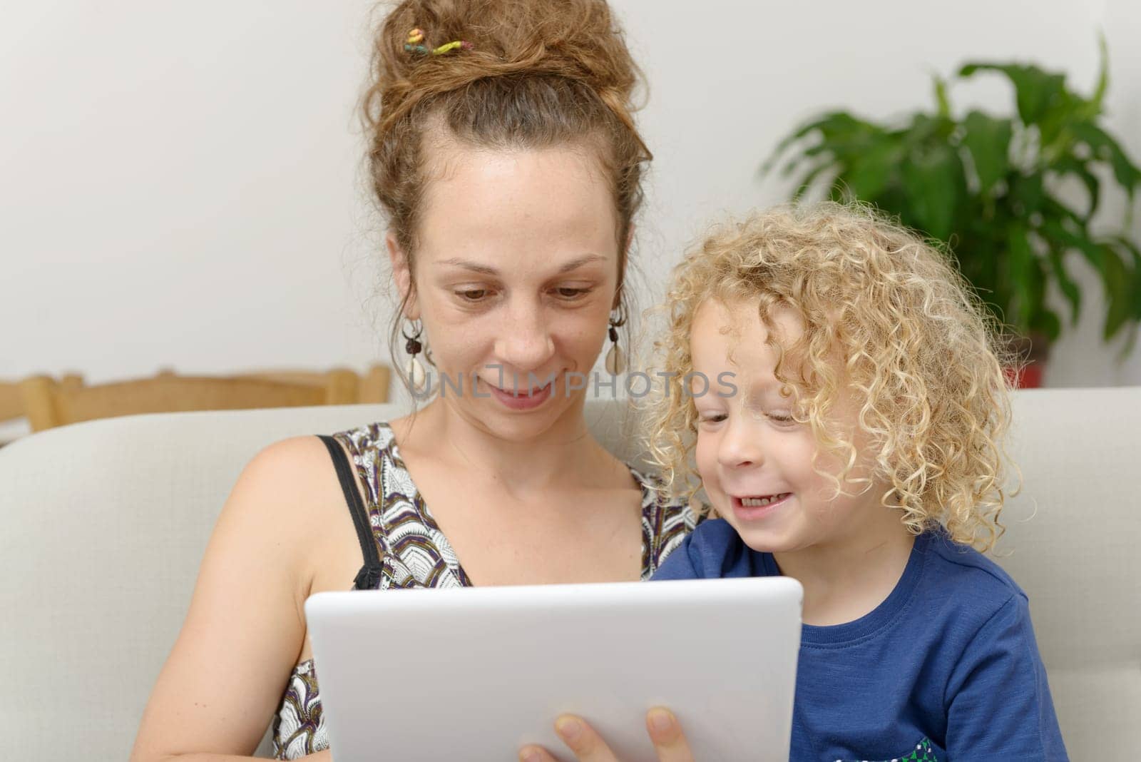 a blond little boy and his mom with a digital tablet