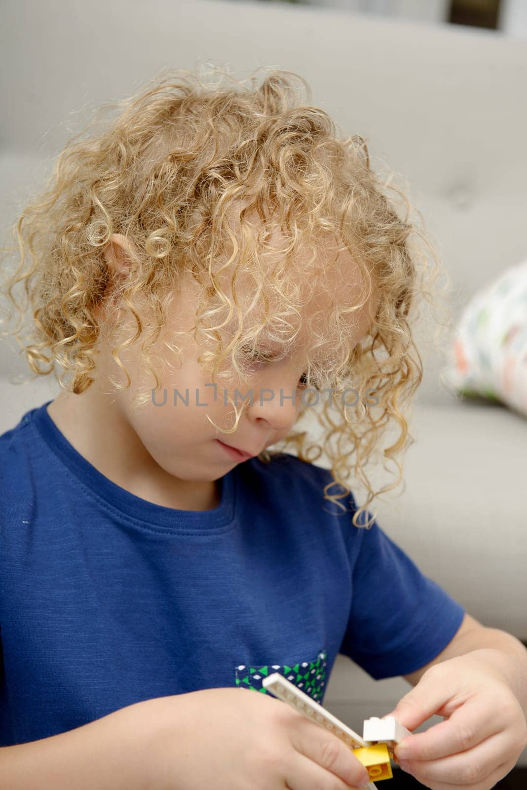 a little blond boy playing with toys