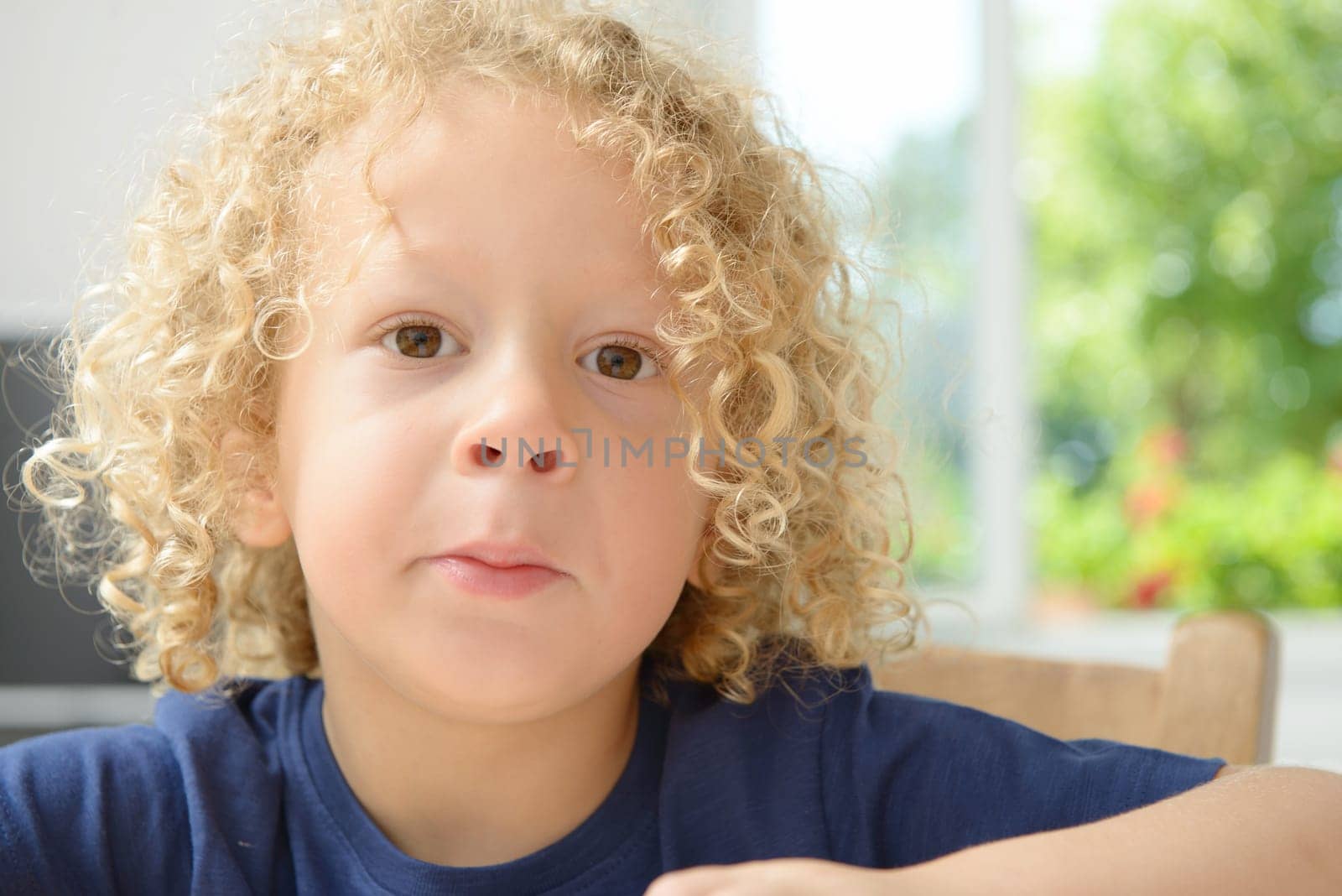 a portrait of a little boy with blond curly hair