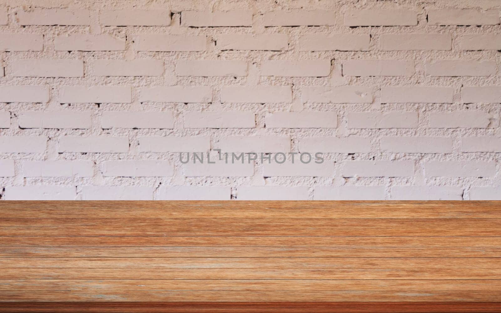 Top of wooden table with white brick wall decorated in coffee shop