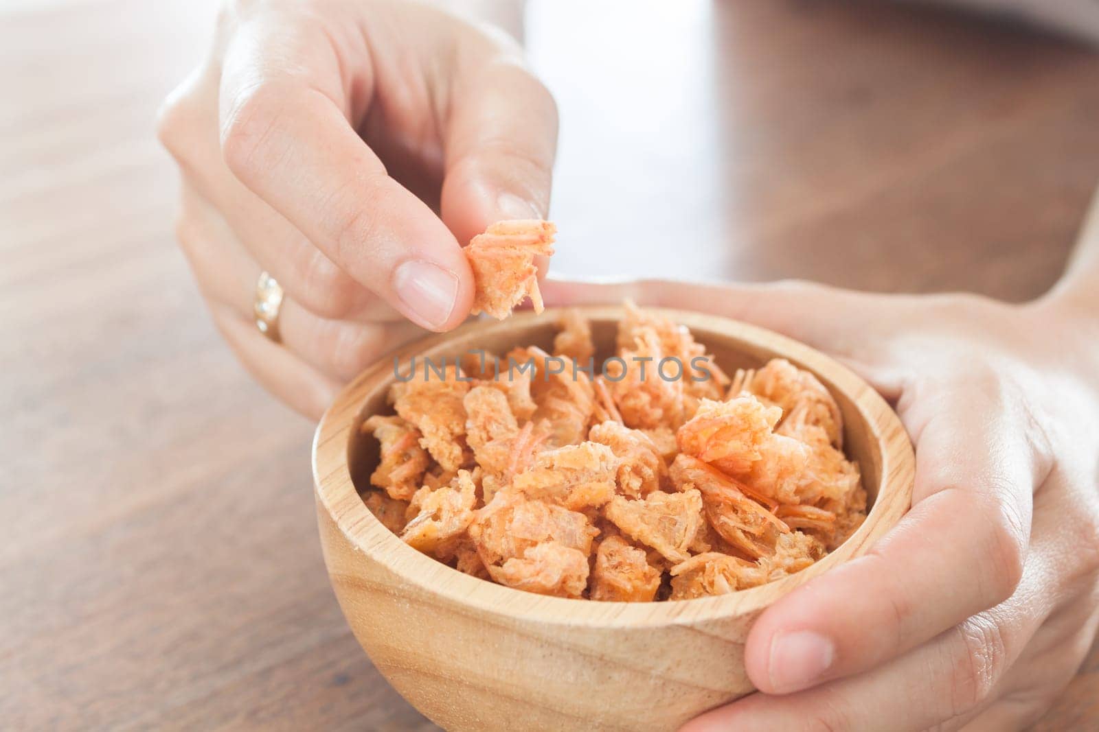 Fried shrimp chins snack in wooden bowl, stock photo