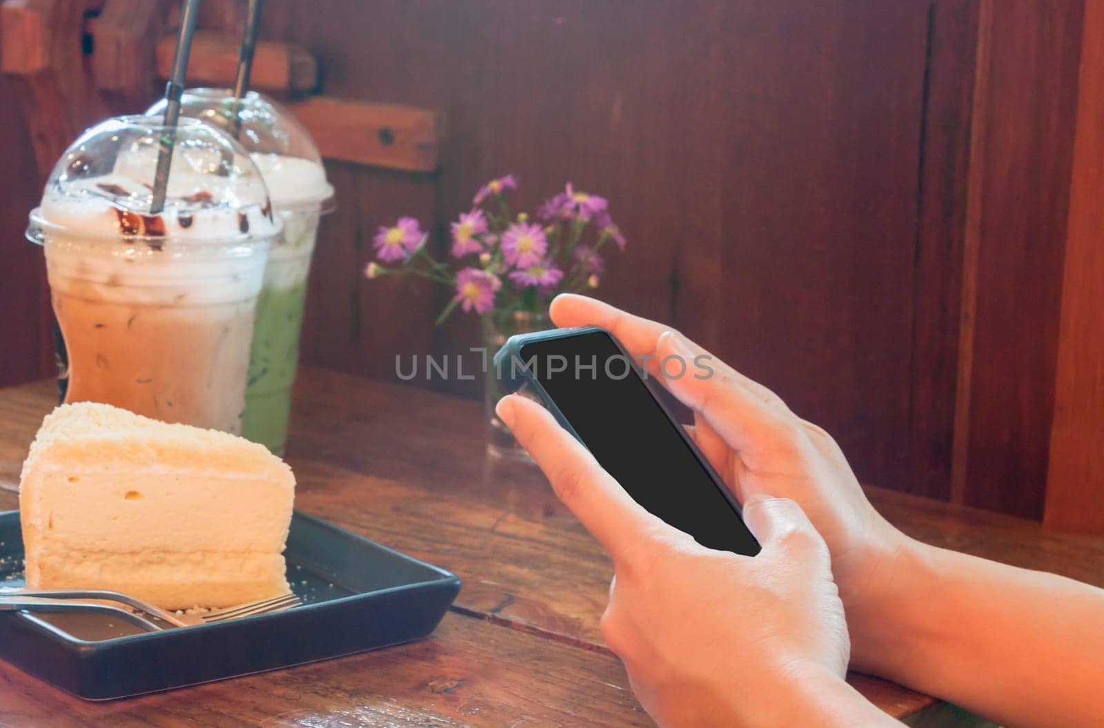 Closeup woman using smartphone in coffee shop, stock photo