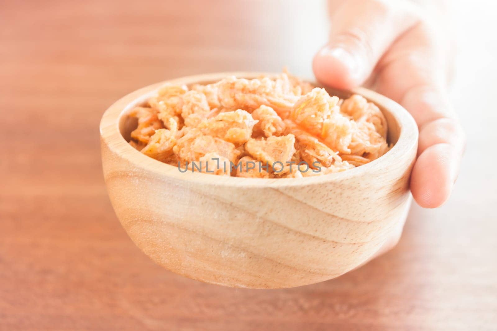 Fried shrimp chins snack in wooden bowl, stock photo
