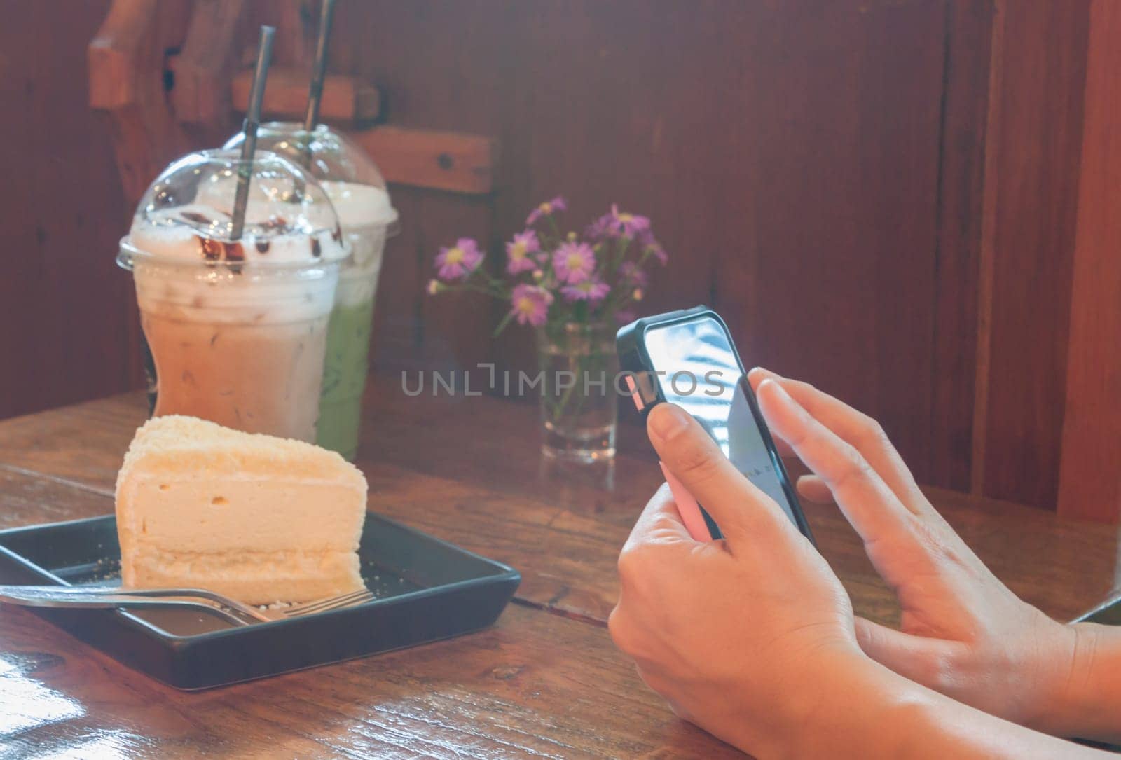Closeup woman using smartphone in coffee shop, stock photo