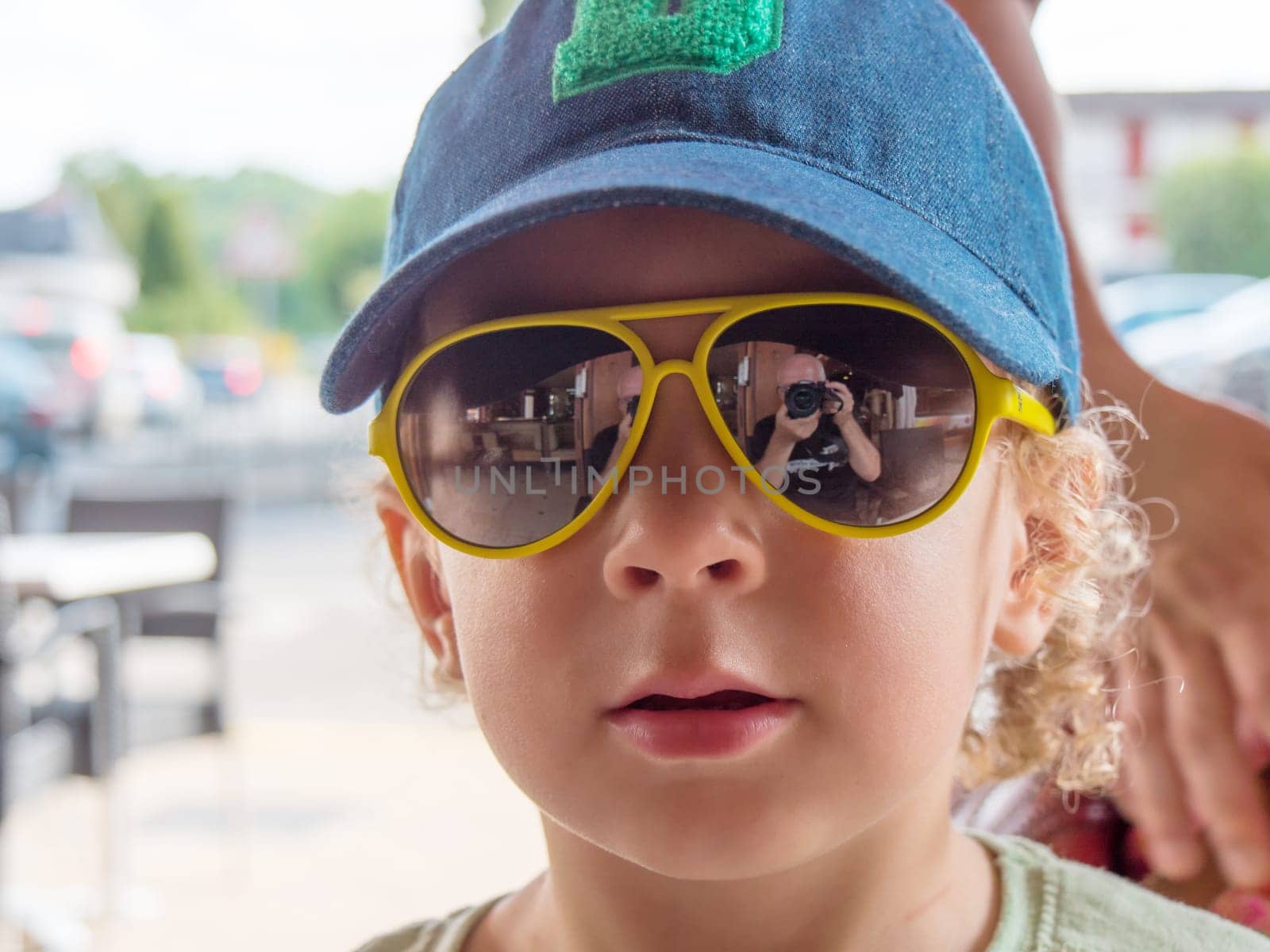 a little boy with a hat and sunglasses