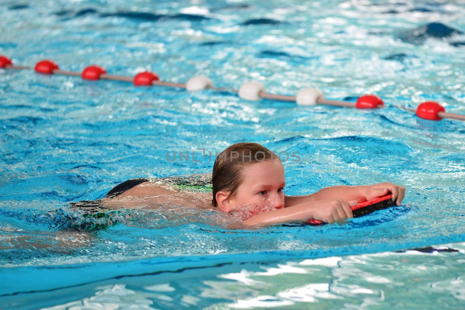 boy swimming with swimming board